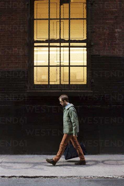 Side View Of Man Walking On City Street Stock Photo