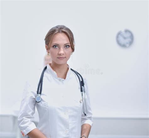 Portrait Of Young Woman Doctor With White Coat Standing In Hospital