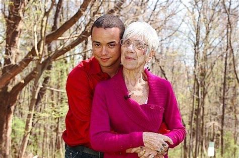 An Older Couple Hugging Each Other In The Woods