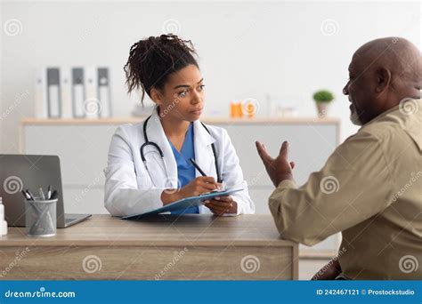 Young Black Doctor Explaining Treatment Plan To Male Patient Stock