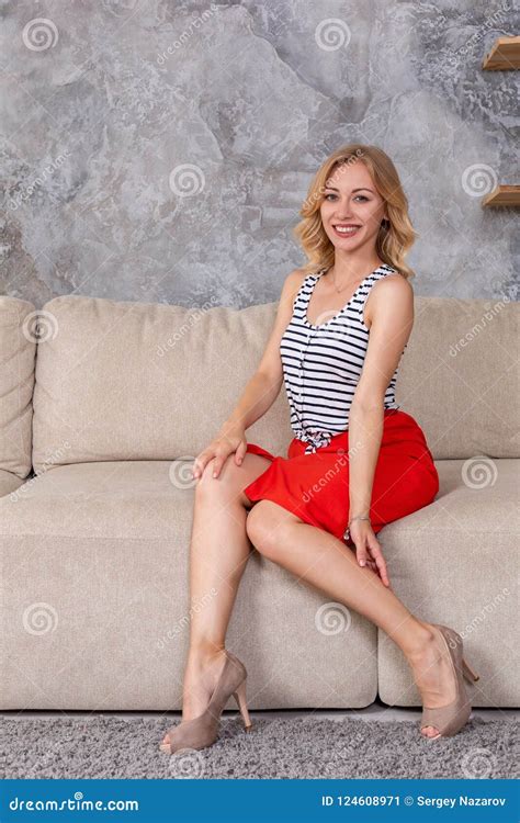 Woman In Fashionable Short Dress Skirt High Heels Sitting On Couch