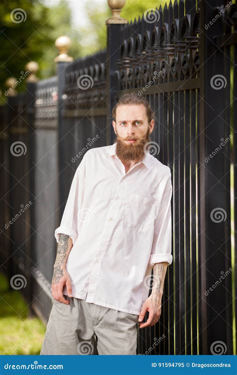Hipster With Long Beard Posing Next To A Fence Stock Image Image Of