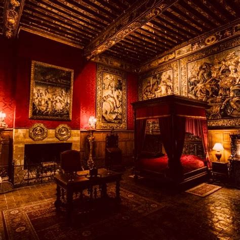 An Ornate Bedroom With Red Walls And Paintings On The Wall Along With