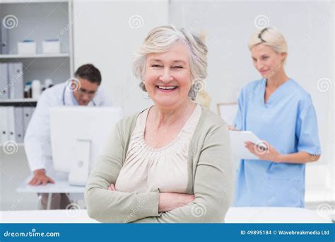 smiling patient receiving a medical consultation and looking at camera the female doctor is