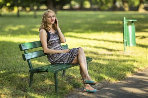 Frau Am Handy Sitzt Auf Einer Bank Im Park Spricht Stockbild Bild von leute grün