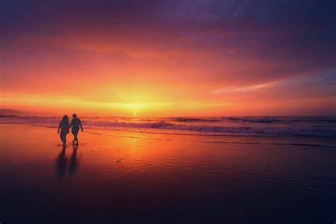 Couple Walking Beach At Sunset