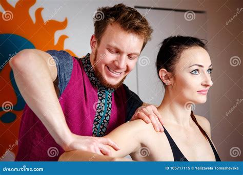 Young Male Massage Therapist Doing Relaxing Massage For A Girl In Black