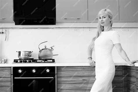 premium photo black and white photo of blonde girl posing on camera standing in kitchen