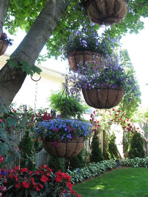Flowers Pots Hanging From Trees Love The Landscaping Along Fence