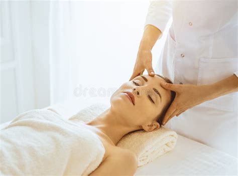 Beautiful Woman Enjoying Facial Massage With Closed Eyes In Sunny Spa Center Relaxing Treatment
