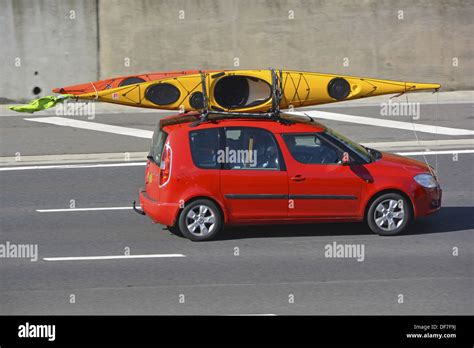 Car Roof Rack Loaded With Two Kayak Canoes Driving Along Motorway Stock