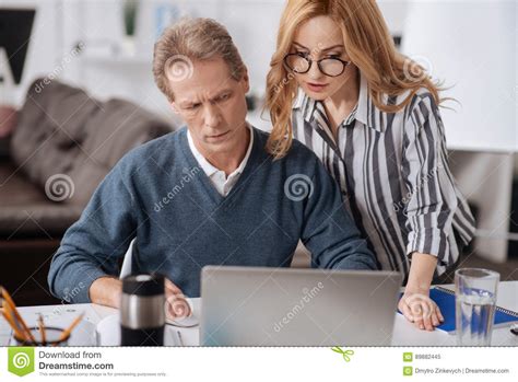 Businesswoman Seducing Mature Colleague In The Office Stock Image