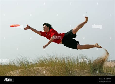 Man In Mid Air Takes Part In Extreme Sport Of Ultimate Frisbee At