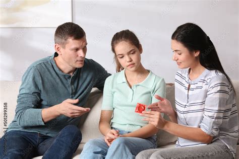 Parents Talking With Their Teenage Daughter About Contraception At Home