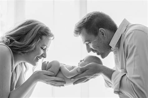 Parents Holding Their Newborn In Their Hands By Stocksy Contributor