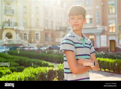 Outdoor Portrait Of Teenager 13 14 Years Old Boy With Crossed Arms