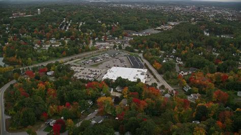 5 5k stock footage aerial video flying over colorful foliage approaching a store tilt down