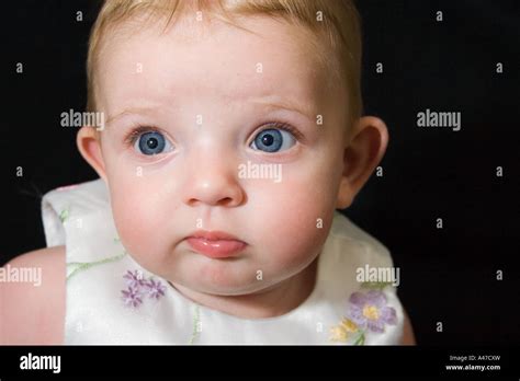 Head And Shoulders Of Serious Little Girl With Pursed Lips Stock Photo