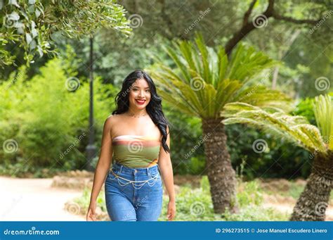 Young And Beautiful Latin Woman From South America Walks Among The Trees And Vegetation Of The