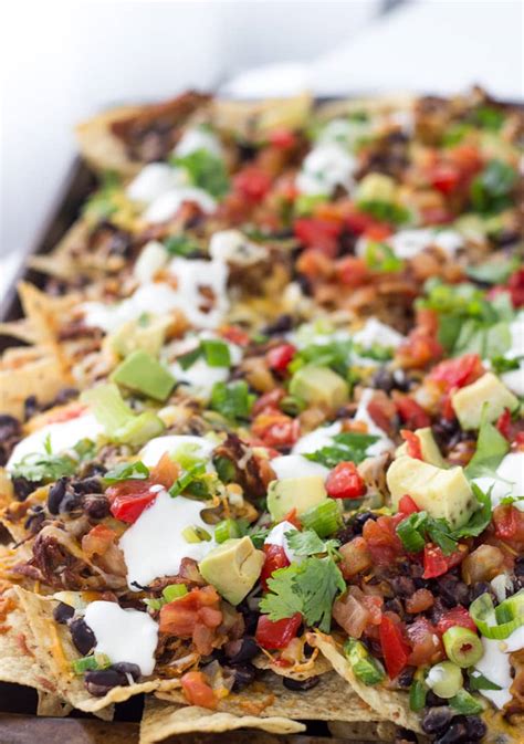 Bake the nachos in the preheated oven until the cheese is melted and the chips around the edges are starting to brown, approximately 8 minutes. Shredded BBQ Chicken Nachos - A Classic Twist
