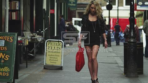 Close Up Young Woman In Mini Skirt Walking On Sidewalk Carrying A