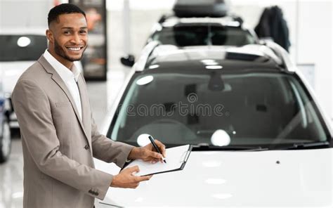 Cheerful Car Sales Manager Standing Near Auto In Store Stock Image