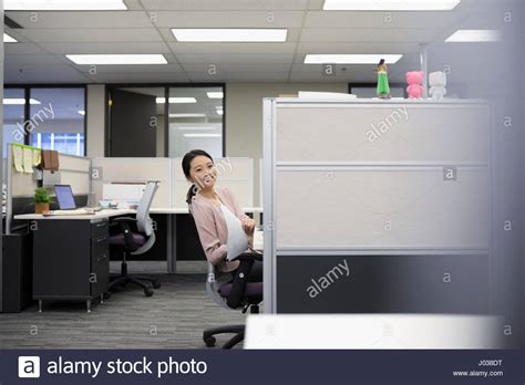 Portrait Smiling Businesswoman With Paperwork At Office Cubicle Stock