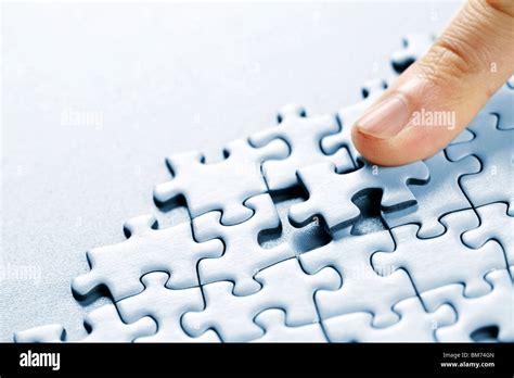 Finger Pushing Missing Puzzle Piece Into Place Stock Photo Alamy