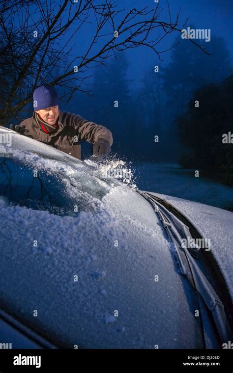 Man Scraping Ice From A Frost Covered Car Windscreen Stock Photo Alamy