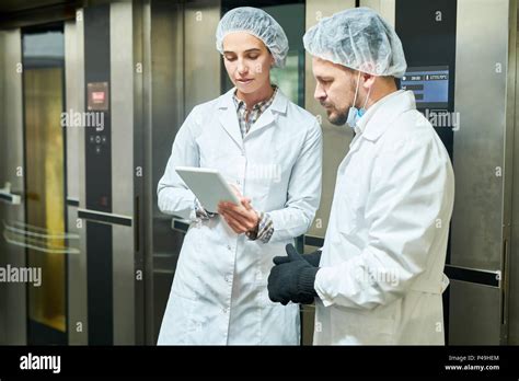 People In Lab Coats Standing And Using Tablet Stock Photo Alamy