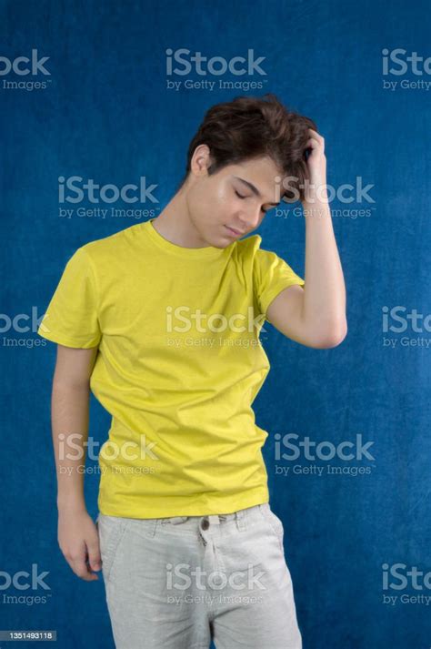 Frustrated Young Man Looking Down Yellow Shirt Isolated On Blue