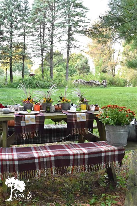 A Picnic Table Set Up With Potted Plants
