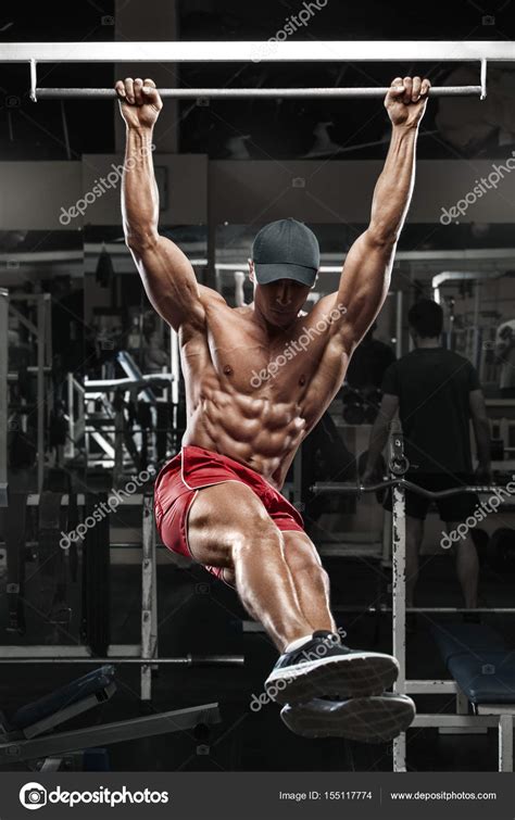 Muscular Man Working Out In Gym Doing Stomach Exercises On A Horizontal Bar Strong Male Naked
