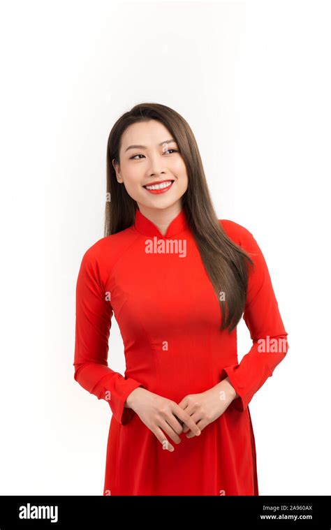 close up portrait of beautiful asian girl dressed in traditional ao dai red dress stands over