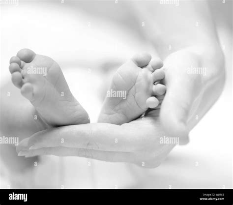 Tiny Newborn Babys Feet On Female Hands Closeup Stock Photo Alamy