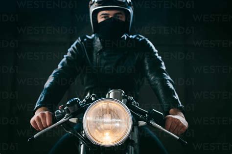 Young Male Motorcyclist On Vintage Motorcycle In Garage Portrait Stock