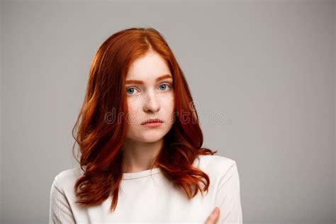 Portrait Of Beautiful Ginger Girl With Magnifier Over White Background