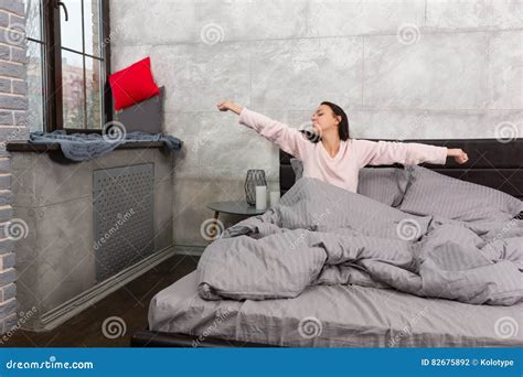Young Beautiful Woman Woke Up And Stretching While Sitting In Th Stock