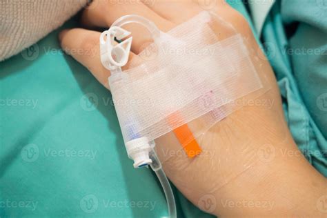Asian Woman Patient Hand On Iv Drip With Saline Solution Fluid