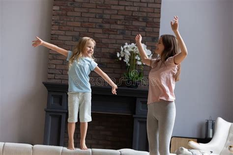 Mother With Daughter Dancing Enjoy Weekend Together At Home Stock Photo