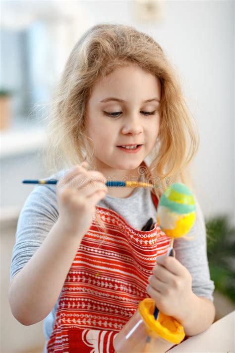 Little Blonde Girl Coloring Eggs For Easter Holiday At Home Stock Image