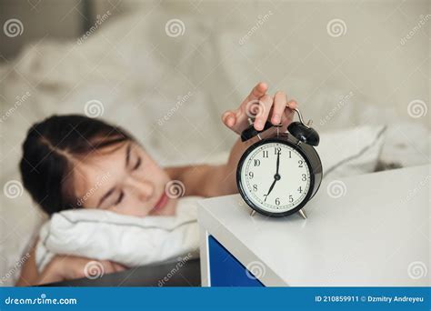Child Wakes Up In The Morning With Alarm Clock On Bed Stock Image
