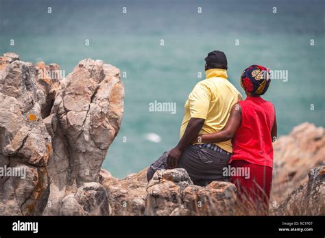 Adult African Couple In Vivid Clothes Admiring The Ocean View In Hermanus South Africa Stock