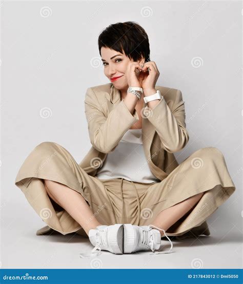 Smiling Beautiful Short Haired Brunette Woman In Beige Business Smart Casual Suit And Sneakers
