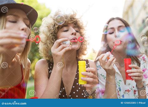 Young Women Blowing Soap Bubbles Outdoors Stock Image Image Of Group Hugging 125653385