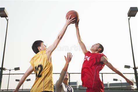 Referee Throwing Ball In The Air Basketball Players Getting Ready For