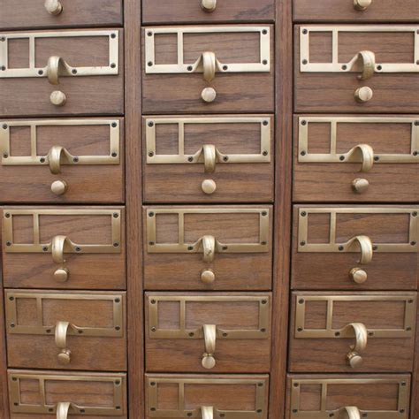 The cabinet sits atop four wooden legs, leaving enough space at the bottom for additional storage. 90 Drawer Wooden Card File Cabinet at 1stdibs