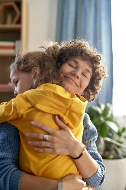Madre Feliz Abrazando A Su Hijo Y Mostrándole Todo Su Amor Foto Premium