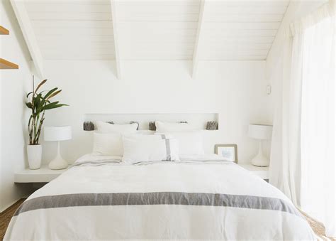 This serene white bedroom gathers decorating inspiration from a large gray and white painting. Decorating Bedrooms With White Walls