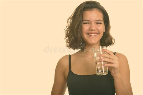 Young Happy Caucasian Teenage Girl Smiling And Holding Glass Of Water